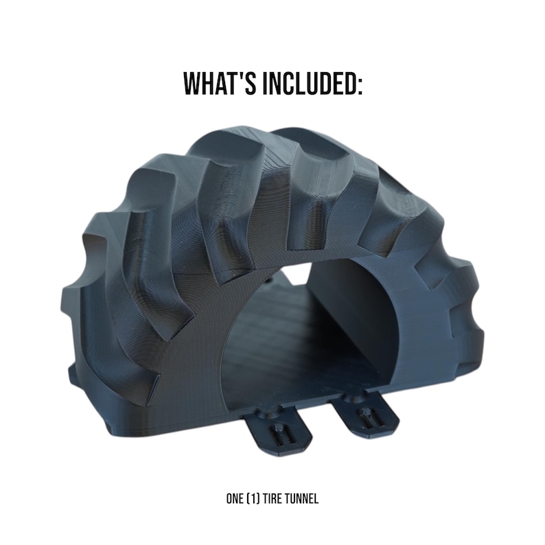 Peut inclure: Un tunnel de pneu noir avec un motif de bande de roulement textur&eacute;. Le tunnel a une ouverture arqu&eacute;e et deux petites languettes &agrave; la base. Le texte "WHAT'S INCLUDED:" et "ONE (1) TIRE TUNNEL" sont affich&eacute;s en noir.