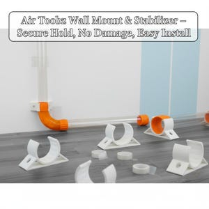 May include: A selection of white plastic wall mounts and orange connectors, alongside clear tubing. The text "Air Toobz Wall Mount & Stabilizer - Secure Hold, No Damage, Easy Install" is visible. The items are arranged on a grey surface.