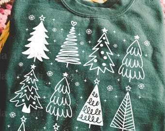 May include: Dark green sweatshirt featuring a white Christmas tree design. The design includes various stylized Christmas trees and snowflakes. The sweatshirt has a crew neck and long sleeves, perfect for the holiday season.