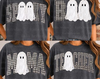 May include: A charcoal grey t-shirt featuring a graphic design with white ghost illustrations and black and white chequered letters. The designs include the words SPOOKY, BOO, MAMA, and TEACHER, with ghosts integrated into the lettering.