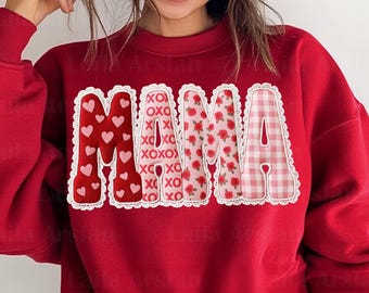 Puede incluir: Sudadera roja con la palabra "MAMA" en un diseño decorativo. La "M" está llena de corazones, la "A" tiene un estampado floral y la otra "M" es un estampado de cuadros. Las letras están delineadas con encaje blanco.