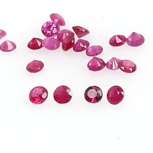 Może przedstawiać: Kolekcja luźnych, okrągłych, fasetowanych rubinów. Rubiny są w różnych odcieniach różowego i czerwonego.