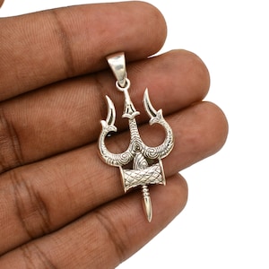 May include: A silver pendant in the shape of a trident, a three-pronged spear, with intricate details. The pendant is a traditional Hindu symbol.