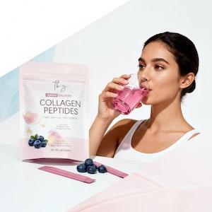 Op de afbeelding: Een roze verpakking Marine Collagen Peptides met bosbessen en een vrouw die een roze drankje drinkt. Op de verpakking staat "thy MARINE COLLAGEN COLLAGEN PEPTIDES HAIR SKIN NAIL JOINT SUPPORT". Nettogewicht 84g.