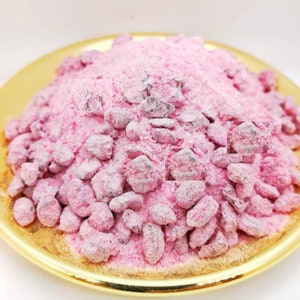 May include: Pink incense powder with small, dark pink pieces mixed in. The powder is in a shallow, gold-coloured dish.