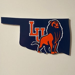 May include: A blue and orange Oklahoma state outline with a lion and the letters "LU" in the center.