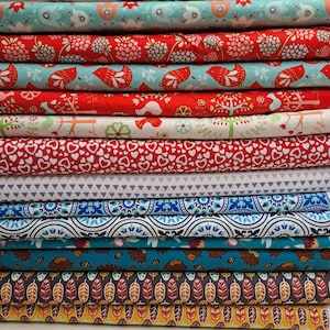 Könnte beinhalten: Ein Stapel verschiedener Stoffe mit Mustern. Die Stoffe zeigen Designs wie Vögel, Herzen und geometrische Formen in Farben wie Rot, Blau und Weiß. Die Stoffe sind wahrscheinlich aus Baumwolle oder einem ähnlichen Material, geeignet für Quilt- oder Bastelprojekte.