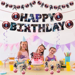 Pu&ograve; includere: Una scena di festa di compleanno con uno striscione che dice "Buon Compleanno" e decorazioni di Captain America. La festa comprende una torta rosa, cupcake e tre bambini con cappellini da festa. Le decorazioni presentano lo scudo e i ritagli dei personaggi di Captain America.