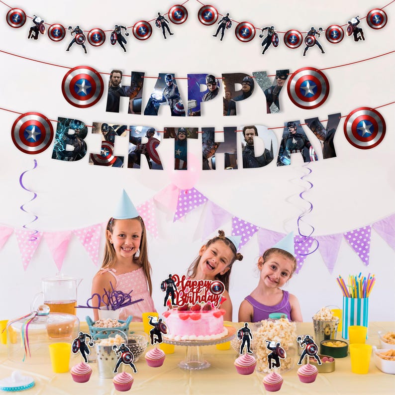Pu&ograve; includere: Una scena di festa di compleanno con uno striscione che dice "Buon Compleanno" e decorazioni di Captain America. La festa comprende una torta rosa, cupcake e tre bambini con cappellini da festa. Le decorazioni presentano lo scudo e i ritagli dei personaggi di Captain America.