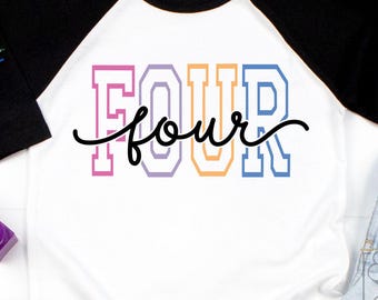 May include: White and black raglan style shirt with the word "FOUR" in colorful block letters and the word "four" in cursive. The shirt is next to a pair of blue jeans and colorful toys.