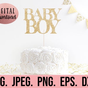 May include: Gold glitter cake topper with the words "BABY BOY" on a white cake with white frosting.