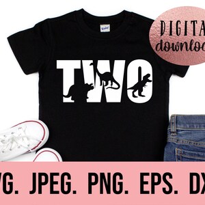 May include: Black t-shirt with white text that says "TWO" with dinosaur silhouettes inside the letters. The shirt is on a white background with a pair of white trainers and blue jeans.