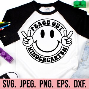 May include: A white and black t-shirt with a black and white peace sign and the text "Peace Out Kindergarten".