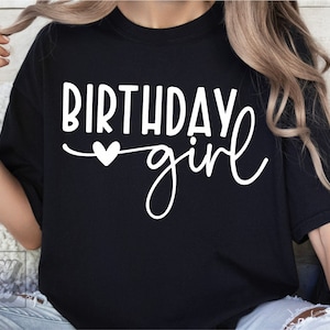 Pode incluir: Camiseta preta com texto branco que diz "Birthday girl" com um pequeno cora&ccedil;&atilde;o.