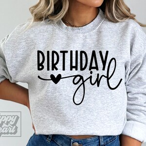 Pode incluir: Uma camisa de moletom cinza com o texto "Birthday girl" em letras pretas com um pequeno cora&ccedil;&atilde;o preto.