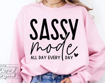 May include: Pink sweatshirt with the text "Sassy mode all day every day" in black lettering with a small heart.