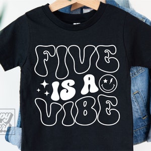 Puede incluir: Camiseta negra con texto blanco que dice "Five is a Vibe" en una fuente retro. El texto incluye una carita sonriente con un rayo.