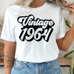 May include: White t-shirt with black text that reads "Vintage 1964" in a retro font.