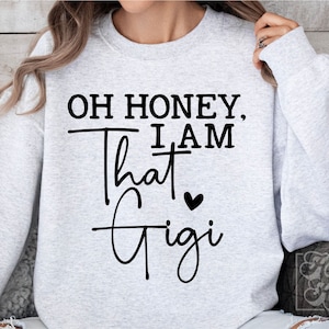 May include: Gray sweatshirt with the text "Oh honey, I am that Gigi" in black with a small heart.