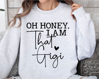 May include: Gray sweatshirt with the text "Oh honey, I am that Gigi" in black with a small heart.