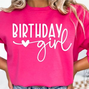 Pode incluir: Uma camisa de moletom rosa com o texto "Birthday girl" em letras brancas com um pequeno cora&ccedil;&atilde;o branco.