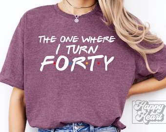 May include: Purple t-shirt with the text "The One Where I Turn Forty" in white with colorful dots.