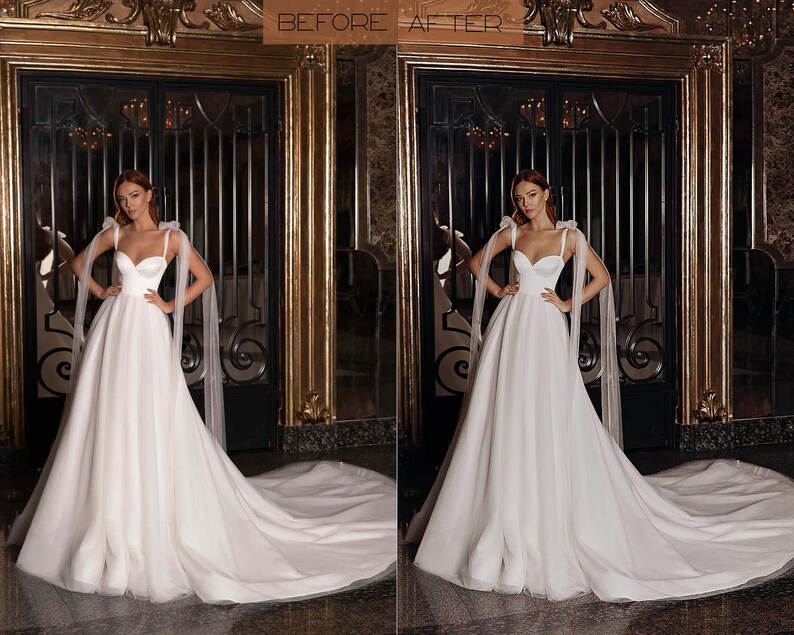 May include: A white wedding dress with a sweetheart neckline and a long train. The dress has tulle straps with bows on the shoulders. The model is standing in front of a gold-coloured door.