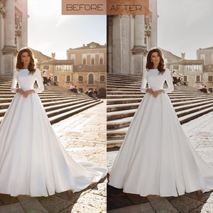 May include: A white wedding dress with long sleeves and a full skirt. The dress is photographed in front of a building with a stone facade.