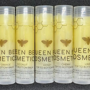 May include: Eight clear tubes of lip balm with yellow labels. Each tube has a bee logo and the text "BEEN BEEEN COSMETICS" and a different flavor name: "Sweet Orange", "Coconut", "Honey", "Cherry", "Lime", "Peppermint", "Bottom Balm", and "Top to Bottom Balm".