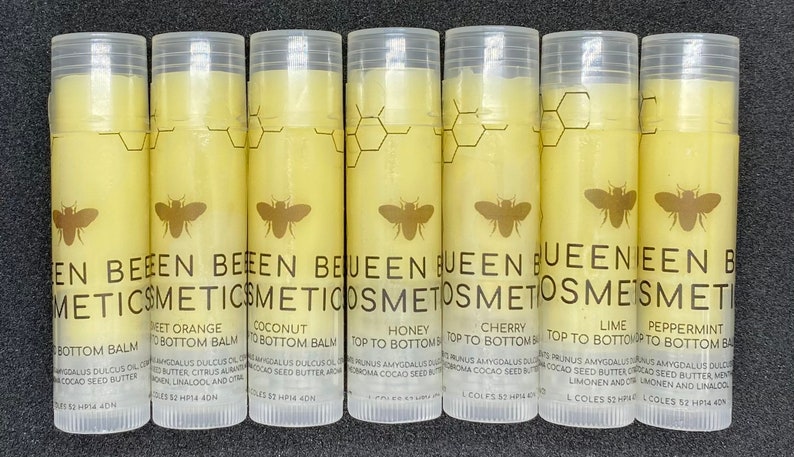 May include: Eight clear tubes of lip balm with yellow labels. Each tube has a bee logo and the text "BEEN BEEEN COSMETICS" and a different flavor name: "Sweet Orange", "Coconut", "Honey", "Cherry", "Lime", "Peppermint", "Bottom Balm", and "Top to Bottom Balm".