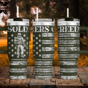 May include: A stainless steel travel mug with a green handle and lid. The mug has a distressed American flag design with white stars and a soldier silhouette. The text "SOLDIERS CREED" is printed on the mug, along with the Soldier's Creed.