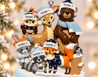 May include: A hanging Christmas ornament featuring a group of six woodland animals including a deer, bear, owl, rabbit, raccoon, and fox. Each animal wears a winter hat with a customizable name tag. The base is labeled YEAR and includes a small bird.