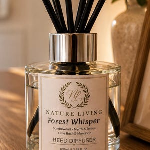 May include: A clear glass reed diffuser with a silver cap and black reeds. The label reads Nature Living Forest Whisper, Sandalwood, Myrrh & Tonka, Lime Basil & Mandarin, Reed Diffuser, 100ml e 3.38 fl. oz, Made in Warwickshire, England.