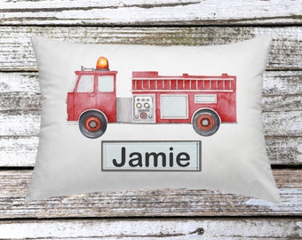May include: A white pillow with a red fire truck illustration and the name "Jamie" printed on a gray rectangle.
