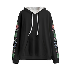 May include: Black hoodie with a white interior and drawstring. The sleeves feature a floral design with pink, green, and blue accents. The hoodie has a front pocket and a white hood lining.