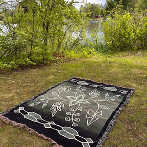 Ojibwe-blommönster i skogsmiljö - Utterspårbård - 60x80 vävd bomullsfilt