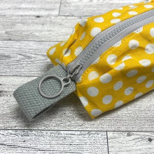 Bolsa de palma con cremallera amarilla y lunares blancos