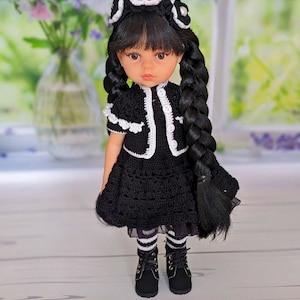 May include: A black and white crocheted dress with a white crocheted collar and a white crocheted headband. The doll has black hair and brown eyes.