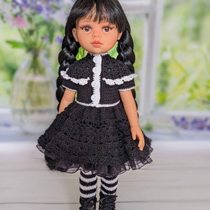 May include: A black and white crocheted dress with a white lace trim and black boots. The doll has black hair in braids and brown eyes.