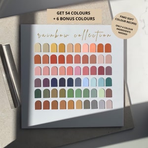 Può includere: Una scatola bianca con una collezione arcobaleno di 60 colori. I colori sono disposti a griglia, ciascuno a forma di arco. Il testo sulla scatola recita "GET 54 COLOURS + 6 BONUS COLOURS" e "FIMO SOFT COLOUR RECIPES ONLY 4 COLOUR INGREDIENTS NEEDED!"