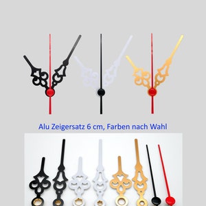 Könnte beinhalten: Satz von sechs 6 cm langen Uhrzeigern in Schwarz, Weiß, Gold und Rot. Die Zeiger haben ein dekoratives Design und sind aus Aluminium.