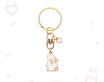 Chaveiro com pingente de coelho rosa e branco dourado