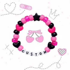 May include: Pink and black beaded bracelet with a star charm, heart charms, and the word "CUSTOM" spelled out in white beads.
