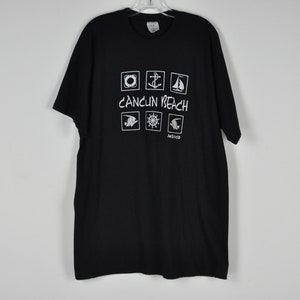 May include: Black t-shirt with a white graphic of nautical symbols and the text "Cancun Beach Mexico".