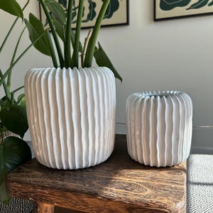 Witte keramische bloempot: moderne verticale lijnen, decoratie voor binnen en buiten