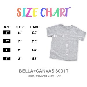 Pu&ograve; includere: Tabella delle taglie per una t-shirt a maniche corte in jersey per bambini piccoli. La tabella mostra le misure del petto e della lunghezza in cm per le taglie 2T, 3T, 4T e 5T. La maglietta &egrave; grigia.