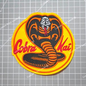 thumbnail interactive-video image 1 of Cobra Kai Strike First No Mercy Patch – Embroidered Iron-On 3.25 Inches 1 of 6