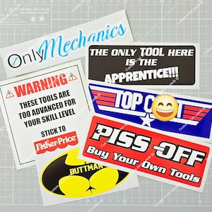 May include: A collection of humorous stickers with various designs and text. One sticker reads "Only Mechanics" in blue script. Other stickers include "WARNING: These tools are too advanced for your skill level," and "Piss Off Buy Your Own Tools."