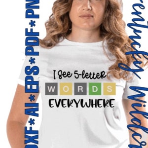 May include: A white t-shirt with the text "I see 5-letter WORDS EVERYWHERE" printed on it. The words "WORDS" are in individual colored squares.