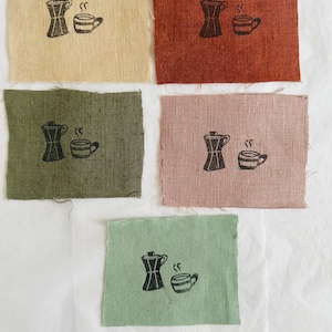 May include: Five fabric swatches featuring a black and white illustration of a coffee pot and a cup of coffee. The swatches are in the colours beige, rust, olive green, pink, and light green.